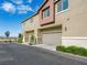 Modern townhouse exterior with two-car garage, neutral colors, and landscaping, set against a bright blue sky at 12112 Polar White Ct # 3, Las Vegas, NV 89183