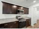 Modern kitchen with dark cabinets, granite countertops, and stainless steel appliances at 12112 Polar White Ct # 3, Las Vegas, NV 89183