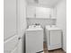 Well-organized laundry room with white washer, dryer, and overhead cabinets, perfect for efficient home management at 12112 Polar White Ct # 3, Las Vegas, NV 89183