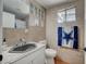 Neutral bathroom with a single sink vanity, tiled walls, and modern fixtures at 1816 Silver Birch Ln, Las Vegas, NV 89104