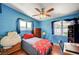 This bedroom features bright blue walls, wood floor, and natural light at 1816 Silver Birch Ln, Las Vegas, NV 89104