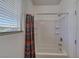 Bathroom with a white tiled shower-tub combination under a bright window at 2099 Port Royal Dr, Laughlin, NV 89029