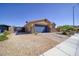 Single-story home featuring desert landscaping, gravel yard, and a two-car garage with a stone facade at 2099 Port Royal Dr, Laughlin, NV 89029
