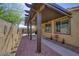 Relaxing covered patio featuring brick flooring, custom overhang, neutral wall color, and desert landscaping at 2099 Port Royal Dr, Laughlin, NV 89029