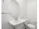Bathroom with a pedestal sink, large mirror, and toilet, all in a clean, neutral palette at 216 Callen Falls Ave # 1423, Henderson, NV 89011