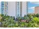 Luxury high-rise with porte-cochere surrounded by lush landscaping, flowers and palm trees at 222 Karen Ave # 3208, Las Vegas, NV 89109