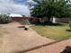 A spacious backyard featuring a mix of grass, gravel, mature trees, and a seating area, perfect for relaxation at 225 Dogwood St, Henderson, NV 89015