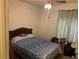 Cozy bedroom features a vintage bed frame, floral curtains, and a ceiling fan with light fixture at 225 Dogwood St, Henderson, NV 89015