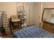Small bedroom featuring a blue patterned bedspread and cluttered storage areas at 225 Dogwood St, Henderson, NV 89015