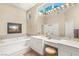 Bright bathroom featuring dual sinks, vanity area, and a luxurious soaking tub at 2346 Villandry Ct, Henderson, NV 89074