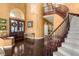 Grand foyer featuring a curved staircase, hardwood floors, and elegant lighting at 2346 Villandry Ct, Henderson, NV 89074