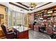 Spacious home office with built-in bookshelves, a large desk, and ample natural light from bay windows at 2346 Villandry Ct, Henderson, NV 89074