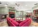 Spacious living room featuring a fireplace, plush pink sofas, and easy access to the dining area and bar at 2346 Villandry Ct, Henderson, NV 89074