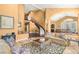Spacious living room featuring a curved staircase, fireplace, and comfortable seating at 2346 Villandry Ct, Henderson, NV 89074
