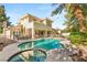 A sparkling pool and spa sit behind a well-maintained home with an outdoor dining and seating area at 2346 Villandry Ct, Henderson, NV 89074
