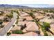 Elevated view of the neighborhood showcasing the tile roofs and mature landscaping with mountains in the distance at 2373 Ozark Plateau Dr, Henderson, NV 89044