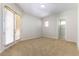 A simple bedroom with carpeted floors, neutral walls, and a sliding glass door that leads to the outside at 2373 Ozark Plateau Dr, Henderson, NV 89044