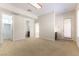 A large carpeted bedroom with neutral-colored walls, several doorways, and a view of the bathroom at 2373 Ozark Plateau Dr, Henderson, NV 89044