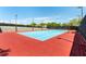 Bright tennis court with blue playing surface, surrounded by well-maintained fencing and lighting for recreational enjoyment at 2373 Ozark Plateau Dr, Henderson, NV 89044
