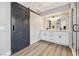 Modern bathroom boasting a sliding barn door, dual vanity, and walk-in shower with sleek, updated finishes at 2409 Alpine Meadows Ave, Henderson, NV 89074