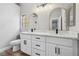 Bathroom featuring dual sinks, quartz countertop vanity, and modern fixtures with an arched mirror at 2409 Alpine Meadows Ave, Henderson, NV 89074