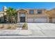 Inviting two-story home with arched windows, a tile roof and an attached two-car garage at 2409 Alpine Meadows Ave, Henderson, NV 89074