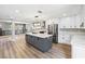 Open kitchen boasts white cabinets, stainless appliances and a large island with seating at 2409 Alpine Meadows Ave, Henderson, NV 89074