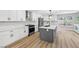 Bright kitchen features white cabinets, stainless appliances, gray island and natural light at 2409 Alpine Meadows Ave, Henderson, NV 89074