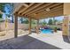 Covered patio view shows landscaping surrounding a lagoon style pool with a rock waterfall feature at 2409 Alpine Meadows Ave, Henderson, NV 89074