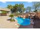Backyard pool featuring a rock waterfall, surrounding palm trees, and ample deck space at 2409 Alpine Meadows Ave, Henderson, NV 89074