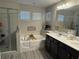 Bathroom featuring dual sinks, a soaking tub, and a glass enclosed shower at 242 Homeward Way, Henderson, NV 89011