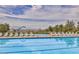 Community swimming pool with lounge chairs and mountain views in the distance at 242 Homeward Way, Henderson, NV 89011