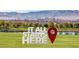 Community welcome sign with a park, pond and Las Vegas skyline in the background at 242 Homeward Way, Henderson, NV 89011