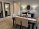 Elegant dining room with a wooden table set for six, complemented by stylish decor and neutral tones at 242 Homeward Way, Henderson, NV 89011