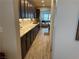 Modern kitchen hallway with dark cabinets, tile backsplash, and stainless steel appliances, leading to the living area at 242 Homeward Way, Henderson, NV 89011