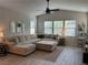 Bright living room featuring a sectional sofa, ceiling fan, and plenty of natural light from the large windows at 242 Homeward Way, Henderson, NV 89011