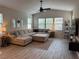Comfortable living room with a large sectional sofa, ceiling fan, and bright natural light from multiple windows at 242 Homeward Way, Henderson, NV 89011