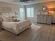 Elegant main bedroom with plank floors, king bed, dresser, and large windows at 242 Homeward Way, Henderson, NV 89011