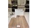 Kitchen finish selection featuring stainless faucet, white shaker cabinets, and wood laminate flooring at 2776 Via Napoli, Henderson, NV 89044