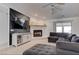Spacious living room with a stone fireplace, dark sectional couch and a sleek, modern television at 2780 Avenue Of The Stars, Pahrump, NV 89060