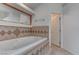 Bright main bathroom featuring a tiled jacuzzi bathtub and a doorway to the bedroom at 2780 Avenue Of The Stars, Pahrump, NV 89060