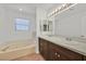 Bright bathroom with soaking tub, double sink vanity, and wood-look flooring at 3935 Tirana Way, Las Vegas, NV 89103