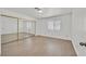 Bright bedroom featuring wood-look floors, natural light, and mirrored closet at 3935 Tirana Way, Las Vegas, NV 89103