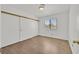 Bedroom with wood-look floors, sliding closet doors and window at 3935 Tirana Way, Las Vegas, NV 89103