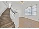Interior shot of staircase with wood stairs, white walls, and a view of a large picture window at 3935 Tirana Way, Las Vegas, NV 89103