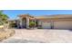 Stunning home features a tile roof, archway entrance, and three-car garage, surrounded by desert landscaping at 4011 Scott Russell Ct, North Las Vegas, NV 89031