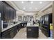 Modern kitchen with dark cabinets, granite countertops, stainless steel appliances and an island at 4011 Scott Russell Ct, North Las Vegas, NV 89031