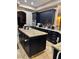 Kitchen with a center island, granite countertops, and black cabinets at 4011 Scott Russell Ct, North Las Vegas, NV 89031