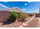 Low maintenance backyard with gravel landscaping, block wall, mature shrubs, and pedestrian gate to alley at 420 Aloha Dr, Henderson, NV 89015
