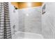 This is a close up of a bathtub featuring attractive marble style tile, a recessed soap box, and a shower head at 420 Aloha Dr, Henderson, NV 89015
